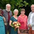 Eine Gruppe von Menschen steht draußen im Grünen. 