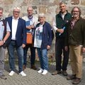 Eine Gruppe von Menschen steht vor einer Kirche.